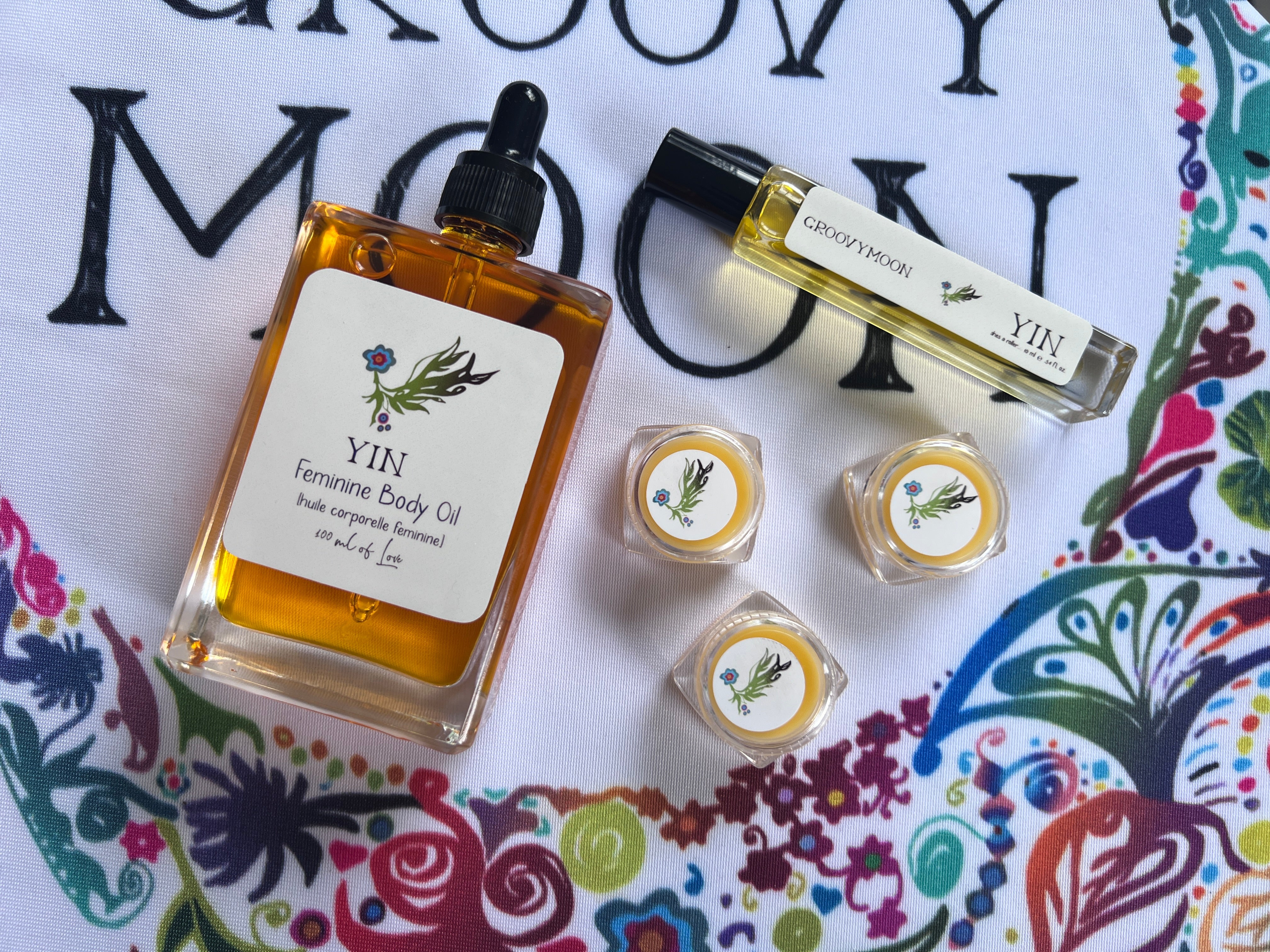 Yin feminine body oil and other products on a colorful background with text.